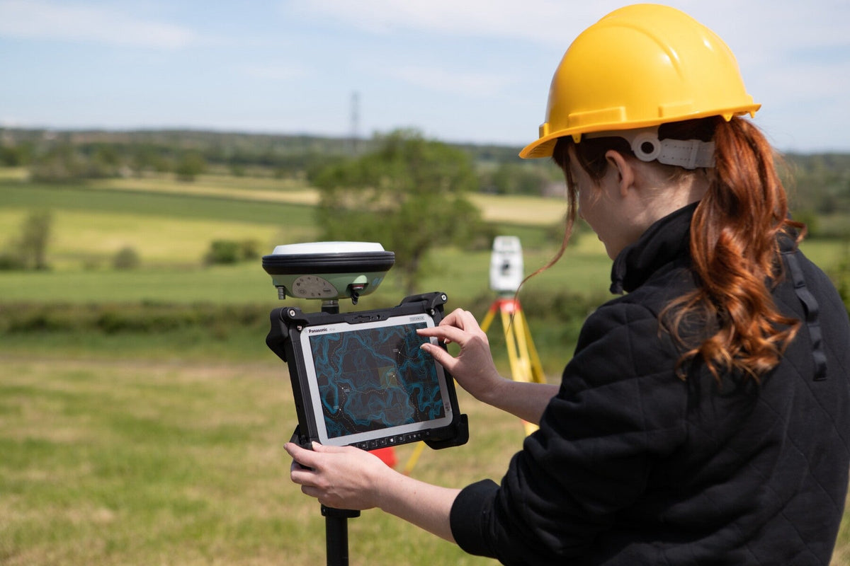 Surveyor using the Panasonic TOUGHBOOK G2 mk3 (4G LTE, micro-SD reader, fingerprint reader, UK plug) on a GNSS pole for field mapping and GIS data capture