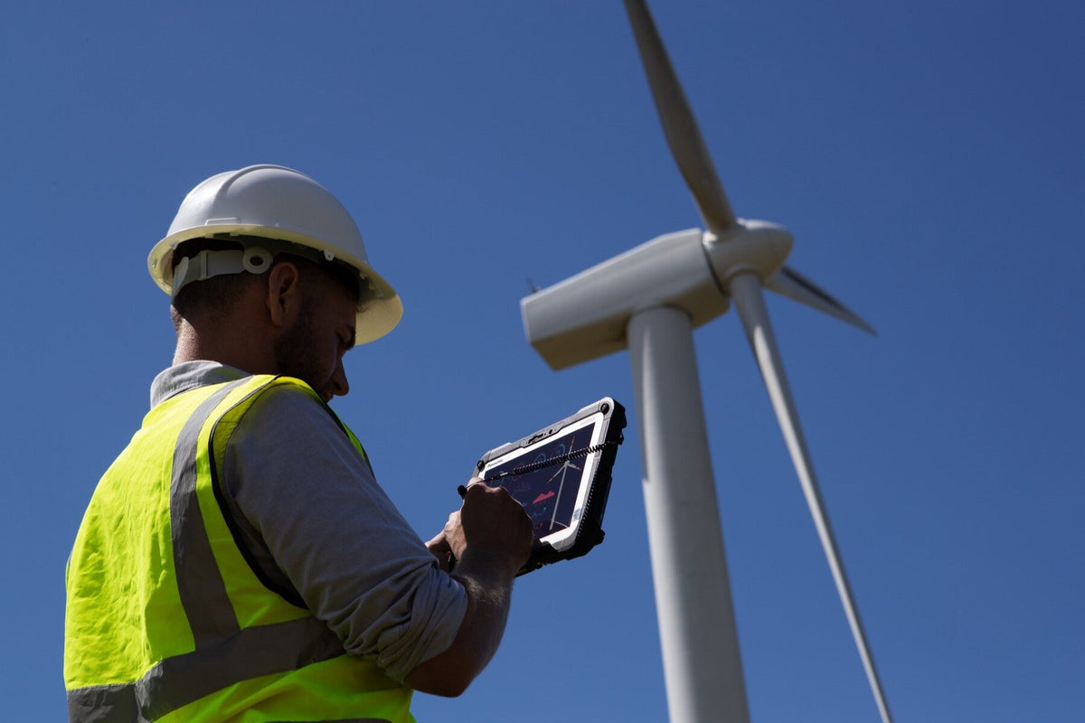 Wind farm engineer using the Panasonic TOUGHBOOK G2 mk3 (5G, UK plug) rugged tablet outdoors in direct sunlight