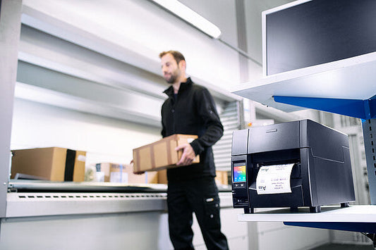 Citizen CL-S700III industrial label printer, black Hi-Open metal case, colour touch LCD, tear bar, 203 dpi, thermal transfer (CLS700IIINEXXX) – in use printing shipping labels in a warehouse